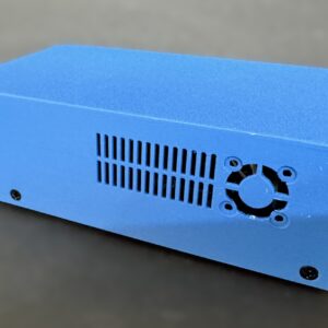 Blue rectangular electronics enclosure with ventilation slots and a circular fan opening on its side, secured by visible screws and resting on a dark surface.