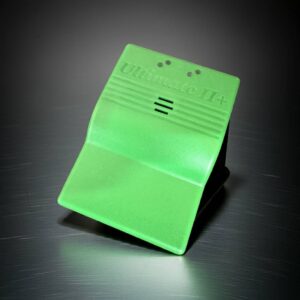 Bright green plastic clamp labeled "Ultimate II+" with ribbed top, three small holes and three central slits, standing tilted on a brushed metal surface with a soft shadow.