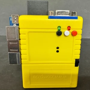 Yellow rectangular electronic module standing upright on a gray surface, with stacked metal ports on the left, a blue-bordered D-sub connector at the top, three small colored indicator LEDs/buttons (green, white, red) on the front, and embossed text on the lower face.