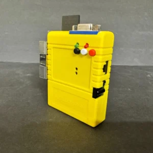 Small bright yellow rectangular electronic adapter standing upright on a dark gray surface, featuring a metal DB9 connector on top, three small colored indicator LEDs and buttons on the front, side ports and a black slide switch.